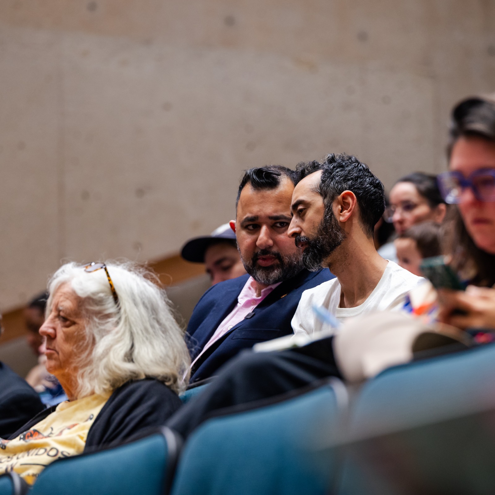 Zeeshan Hafeez seated with residents at a community meeting